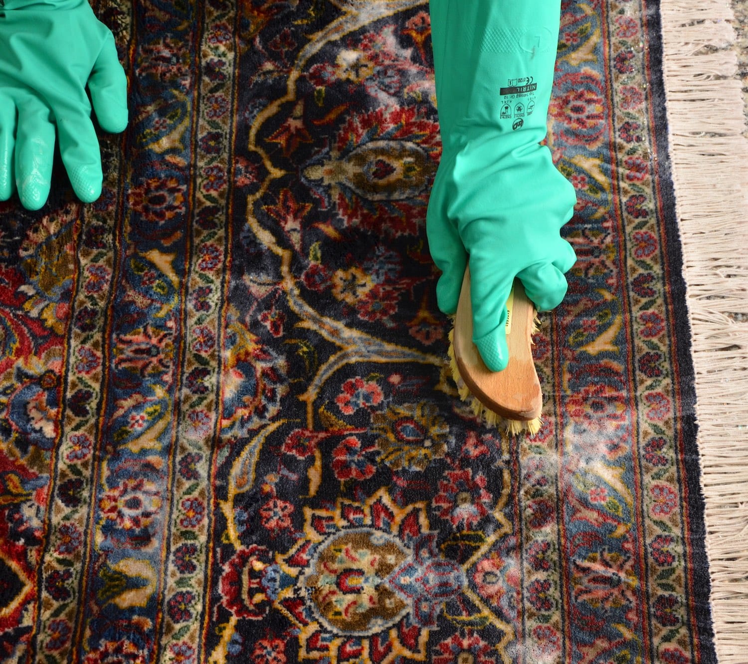 Handwashing handmade Kashan rug with a brush